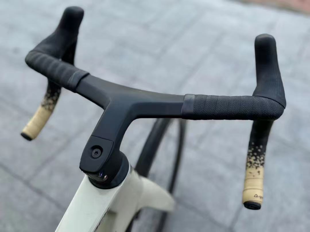 TOCCAY one-piece carbon cockpit mounted on a road bike with beige bar ends