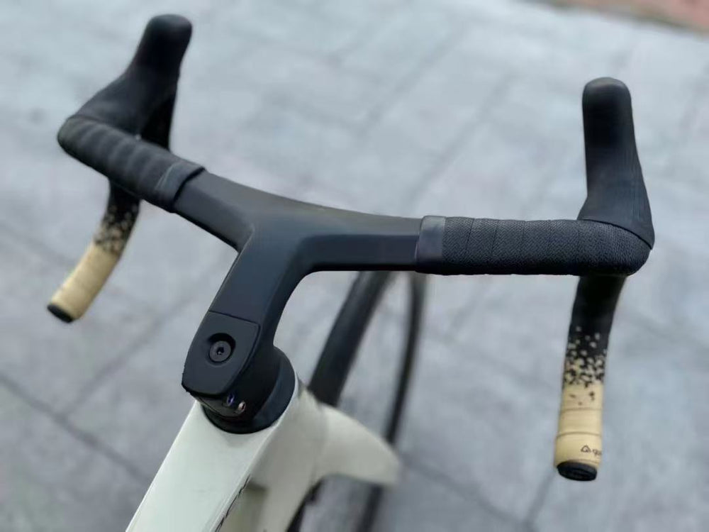 TOCCAY one-piece carbon cockpit mounted on a road bike with beige bar ends